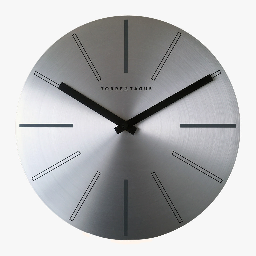 Axis Aluminum Wall Clock, Metric. A modern metal wall clock with a brushed aluminum finish.