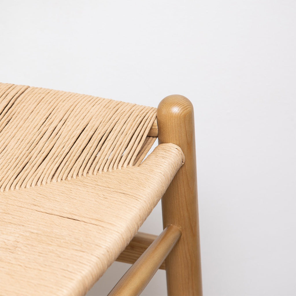 Pic. 2 close-up seat and leg detail of the Frida Counter Stool, blonde. A minimalist counter stool inspired by the mid-mod 1950s Hans J Wegner wishbone chairs with a Y-back design, curving top rail and tapered legs details.